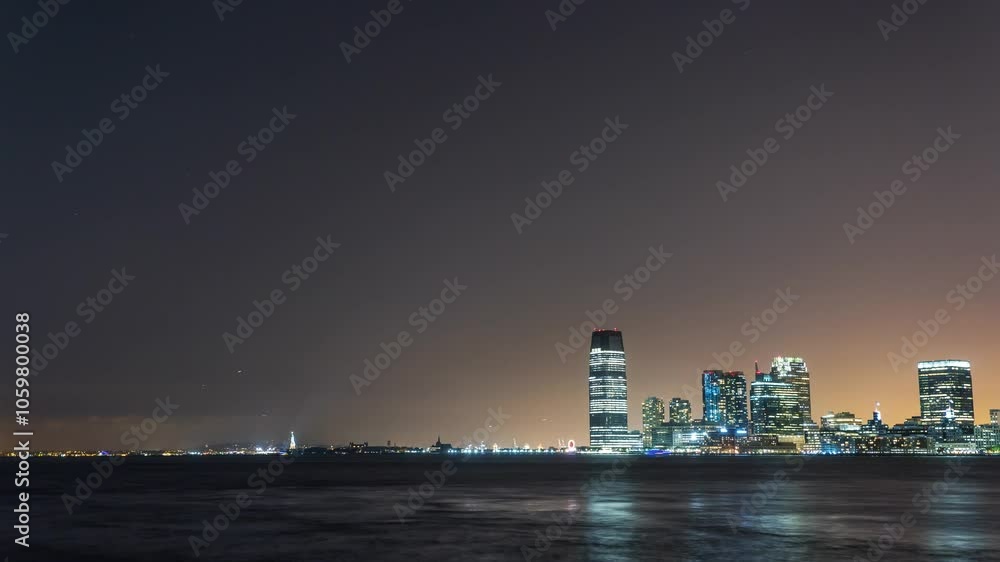 NEW YORK , USA - OCTOBER 27, 2024: Spectacular skyline view over the water showcasing illuminated buildings during nighttime NEW YORK , USA - OCTOBER 27, 2024: Spectacular skyline view over the water showcasing illuminated buildings during nighttime