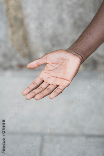 A single open hand reaching out against a textured background, symbolizing trust.