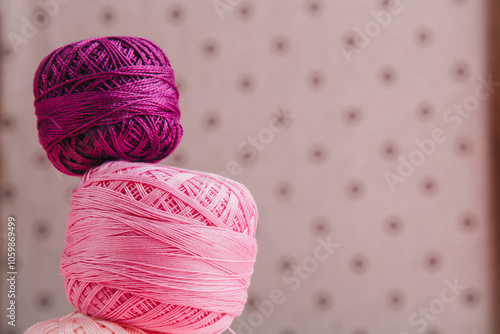 Beautifully arranged yarn balls in pink shades and lace ribbon, ideal for textile, knitting, and crafting themes. photo