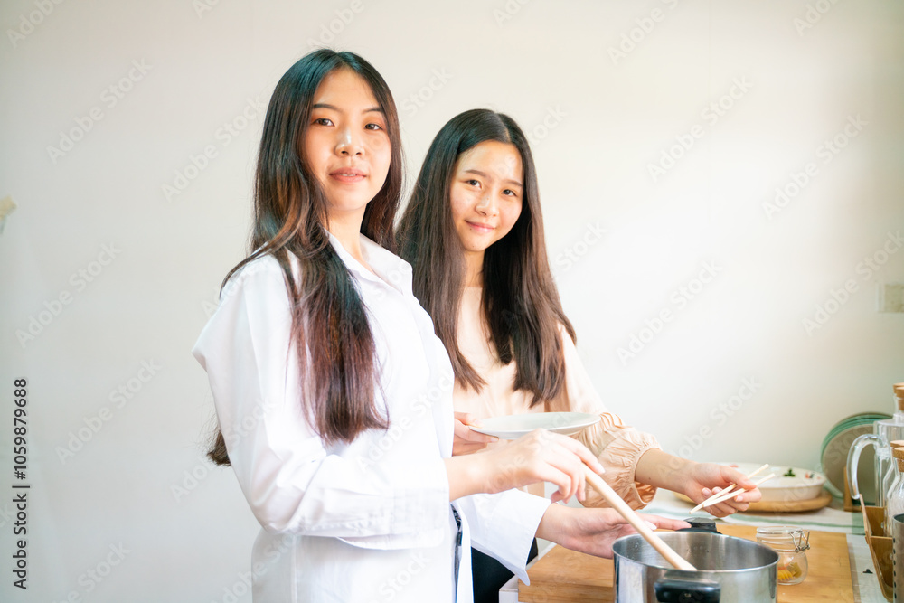 Fototapeta premium Happy asian women cooking breakfast food in home kitchen together