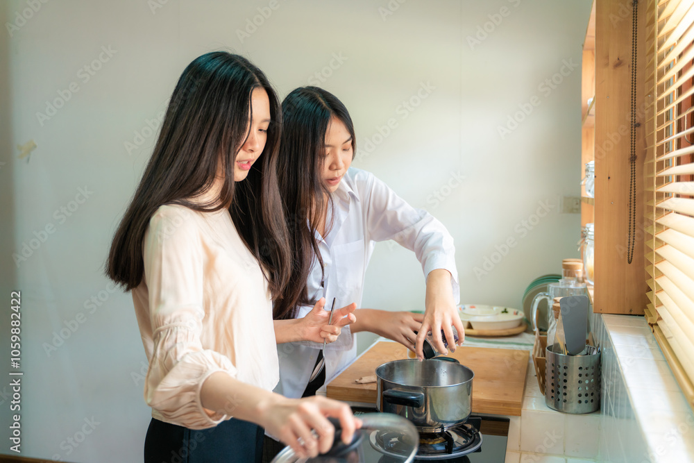 Fototapeta premium Happy asian women cooking breakfast food in home kitchen together
