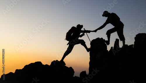 Silhouette of People helping on peak mountain and sunrise background climbing team work success business concept. People on peak mountain climbing helping team work.