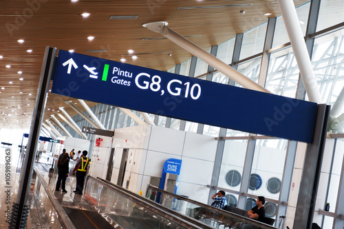 Canvas Print KLIA T1 or Kuala Lumpur International Airport Terminal 1 boarding gate signage on top of the moving walkways or travelator and people in the waiting area for international flight or delay in flight