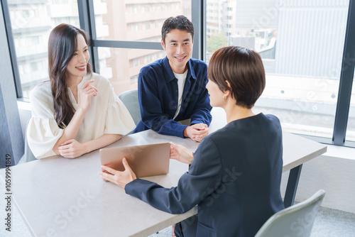 不動産の女性営業マンと客夫婦 photo