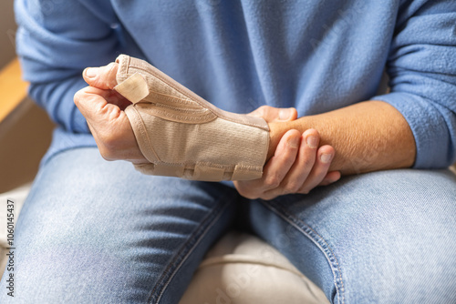 Close-Up Of Injured Hand Wearing Wrist Brace For Pain Relief, Recovery And Rehabilitation – Orthopedic Support For Hand And Wrist Stability After Accident, Strain, Or Sports Injury photo