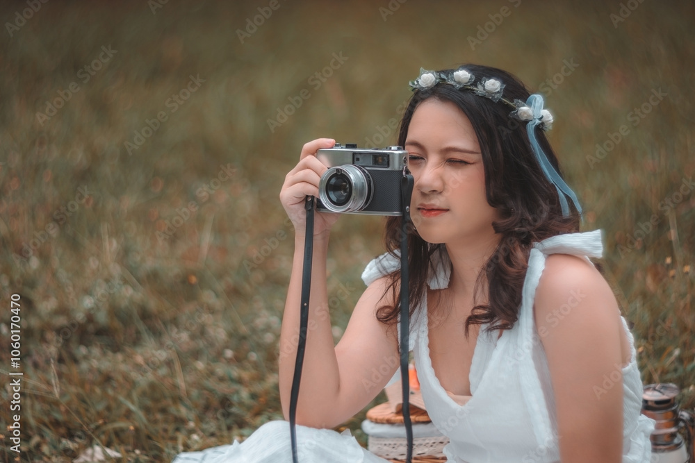 A young woman captures nature's beauty with her vintage camera while enjoying a picnic outdoors A young woman captures nature's beauty with her vintage camera while enjoying a picnic outdoors