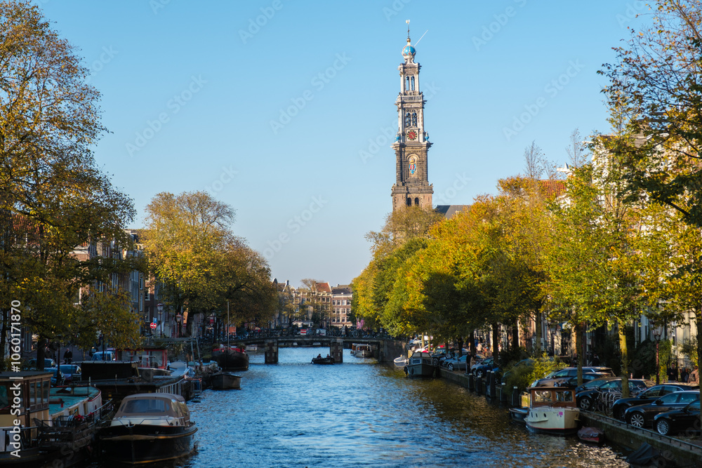 Naklejka premium Autumn vibes along the serene canals of Amsterdam, showcasing the beauty of a crisp blue sky