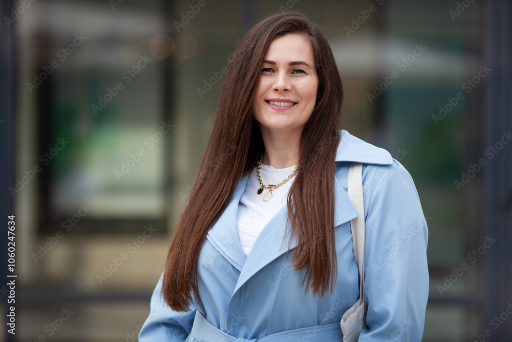 Portrait stylish plus size woman with long hair outdoors, wears fashionable light blue trench coat, showcasing trendy and elegant look in urban setting Portrait stylish plus size woman with long hair outdoors, wears fashionable light blue trench coat, showcasing trendy and elegant look in urban setting