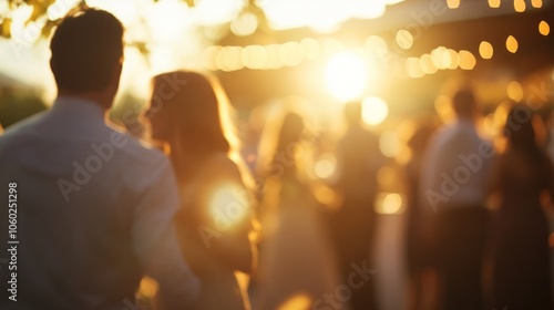 A blurred silhouette of a couple enjoying a sunset gathering, with a group of friends in the background.