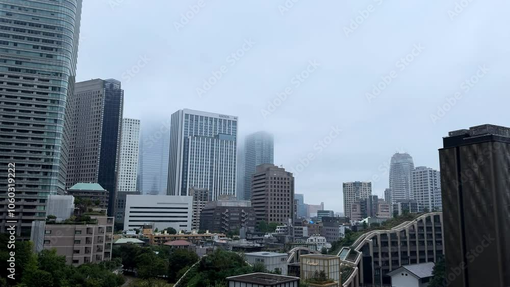 Foggy morning view of Tokyo's Azabudai Hills skyscrapers rising above the cityscape Foggy morning view of Tokyo's Azabudai Hills skyscrapers rising above the cityscape