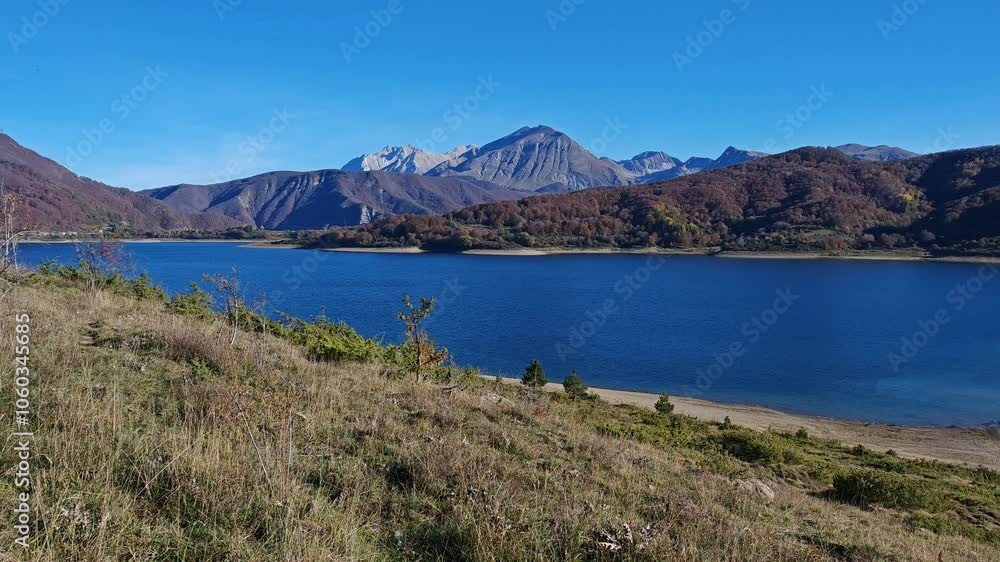 Idyllic view of Campotosto lake with high mountains in the background, Abruzzo region, Italy