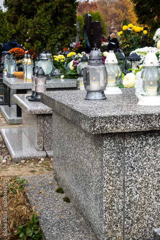 Graves with candles during the All Souls' Day celebration on November 1st. Photo taken during the day in natural light
