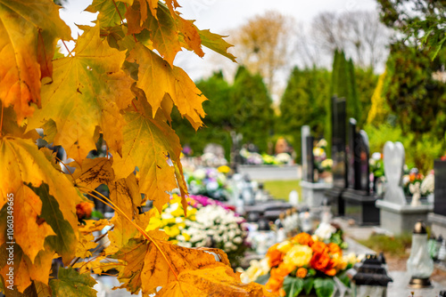 Obraz na płótnie Graves with candles during the All Souls' Day celebration on November 1st. Golden, autumn leaves in the foreground. Photo taken during the day in natural light w salonie