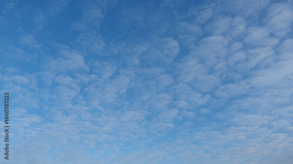 a clear blue sky with scattered, fluffy white clouds. The clouds appear to be thin and spread out across the sky, giving a light and airy feel to the scene. The overall atmosphere is calm and serene a clear blue sky with scattered, fluffy white clouds. The clouds appear to be thin and spread out across the sky, giving a light and airy feel to the scene. The overall atmosphere is calm and serene