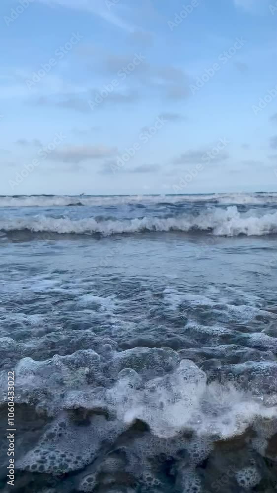 Vertical Video of Ocean Waves Rolling Into Shore on a Beach With Blue Skies and Light Clouds Vertical Video of Ocean Waves Rolling Into Shore on a Beach With Blue Skies and Light Clouds