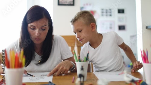 School boy studying with his mother