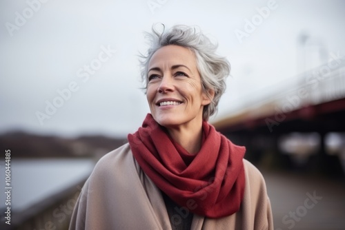 Portrait of a happy senior woman on a bridge over a river