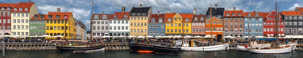 Ultra wide panoramic landscape view of Nyhavn (New Harbour) color houses in Copenhagen, Denmark. Summer cityscape panorama at the famous tourist spot