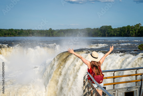 Mujer turista disfrutando del Parque Nacional Iguazú, en Argentina. Contemplando la Garganta del Diablo con los brazos abiertos photo