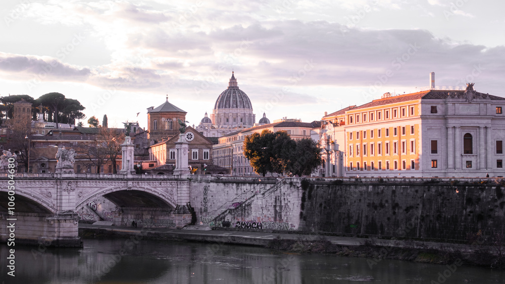 Colorful romantic peaceful sunset over St.Peter's basilica with Tiber river, stone bridge and ancient old stone buildings enlighted by golden colours evokes piety, christianity, calm and refinement. Colorful romantic peaceful sunset over St.Peter's basilica with Tiber river, stone bridge and ancient old stone buildings enlighted by golden colours evokes piety, christianity, calm and refinement.