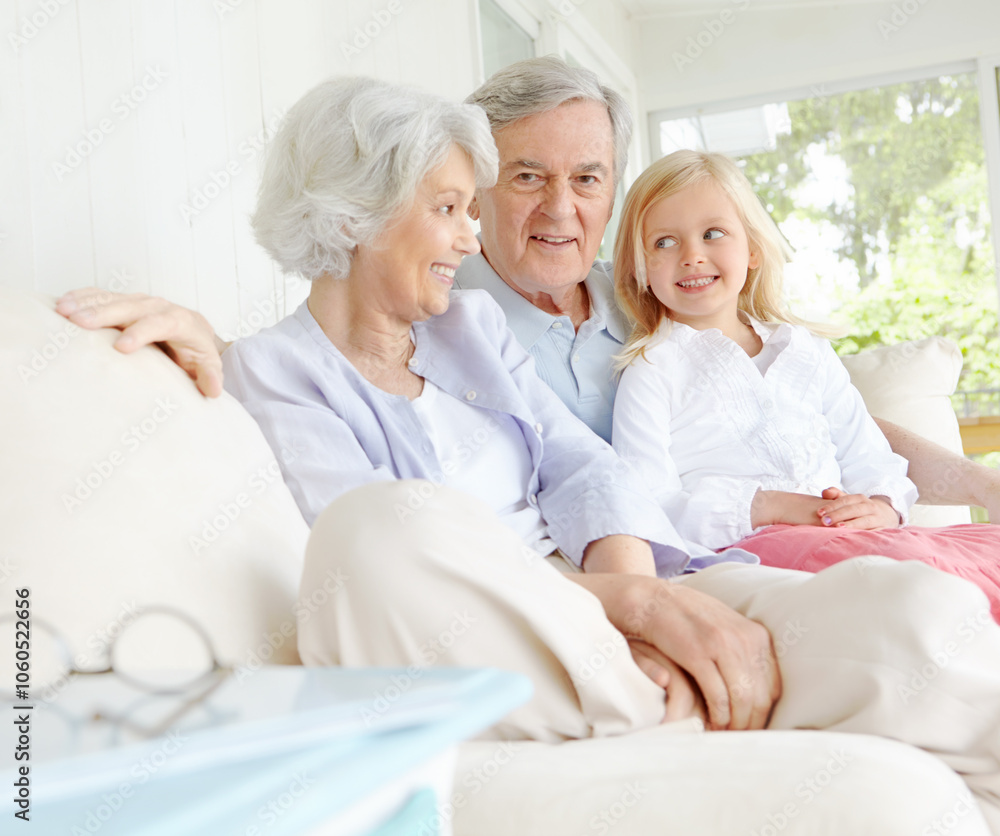 Fototapeta premium Senior man, woman and child in family home or lounge as grandparents with happiness for bonding. Elderly people, little girl and together for love in living room or house for growth, support and care