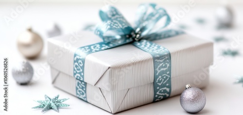 A beautifully wrapped gift box with a blue ribbon, surrounded by festive decorations, perfect for holiday celebrations and special occasions.