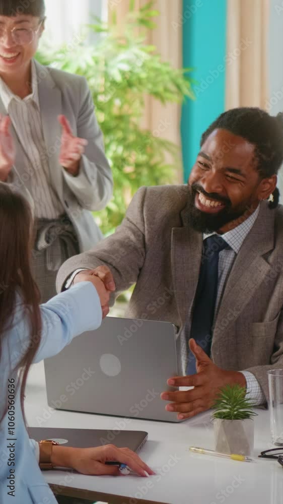 Black businessman and Caucasian woman shake hands and look forward to successful cooperation. They received applause and support from the team. Business people, partnership, and handshake for deal. Black businessman and Caucasian woman shake hands and look forward to successful cooperation. They received applause and support from the team. Business people, partnership, and handshake for deal.