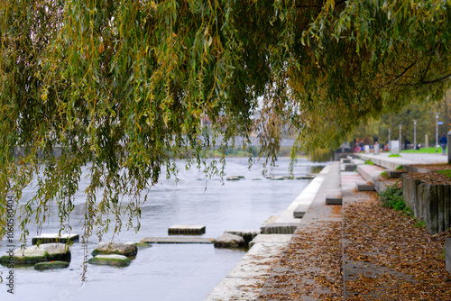 Limmat River with autumn trees and embankment with concrete steps at Swiss City of Zürich on a foggy autumn day. Photo taken November 2nd, 2024, Zurich, Switzerland.