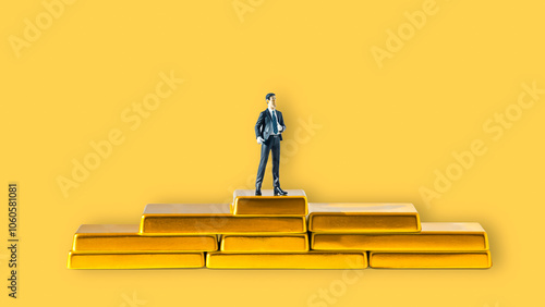 figurine stands victoriously atop a stack golden bars photo