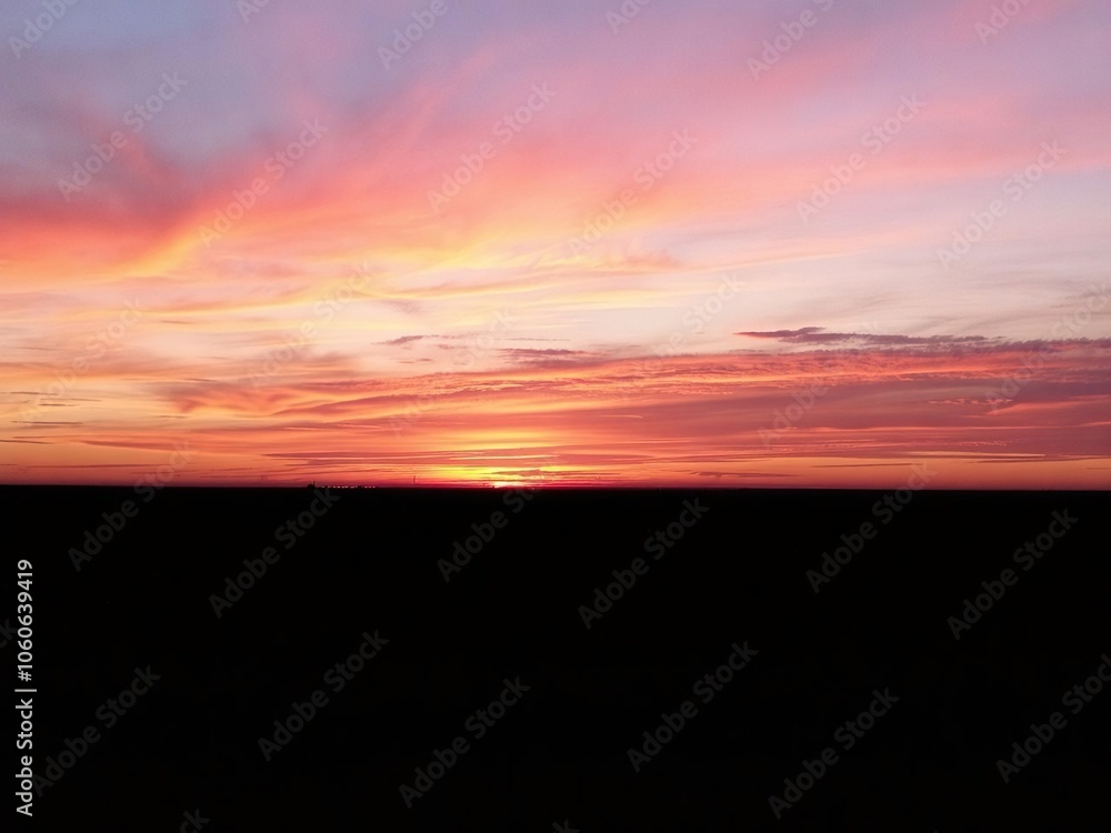 Fototapeta premium Vibrant gradient of oranges, pinks, and purples in a mesmerizing sunset over the horizon, peaceful, vibrant