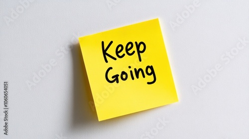 A bright yellow sticky note with the motivational phrase "Keep Going" written in black.