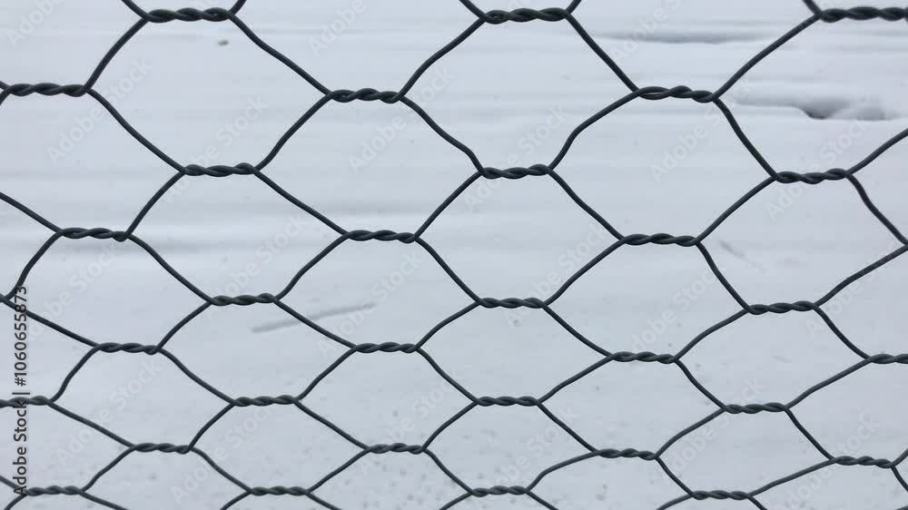 Close-Up of Hexagonal Wire Mesh Fence Against Snow-Covered Ground in Winter. Ideal for Concepts of Isolation, Boundaries, Winter Protection, Security, and Minimalist Backgrounds Close-Up of Hexagonal Wire Mesh Fence Against Snow-Covered Ground in Winter. Ideal for Concepts of Isolation, Boundaries, Winter Protection, Security, and Minimalist Backgrounds