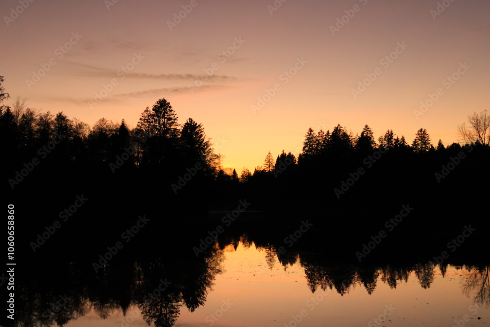 Beautiful sunset reflection with forest in a lake, Waldsee Lindenberg im Allgäu
