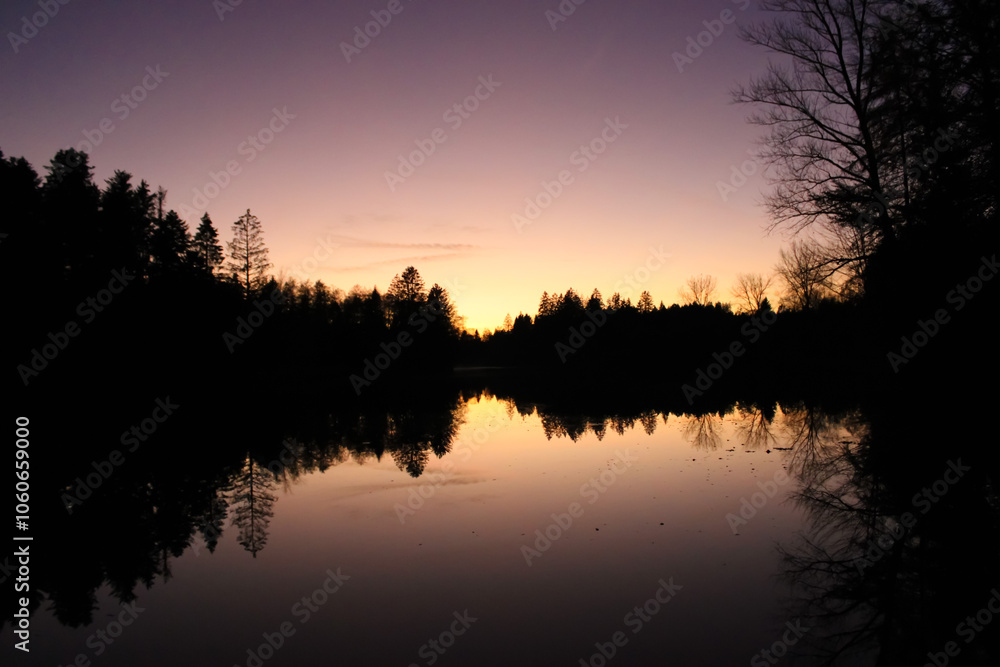 Beautiful sunset reflection with forest in a lake, Waldsee Lindenberg im Allgäu Beautiful sunset reflection with forest in a lake, Waldsee Lindenberg im Allgäu