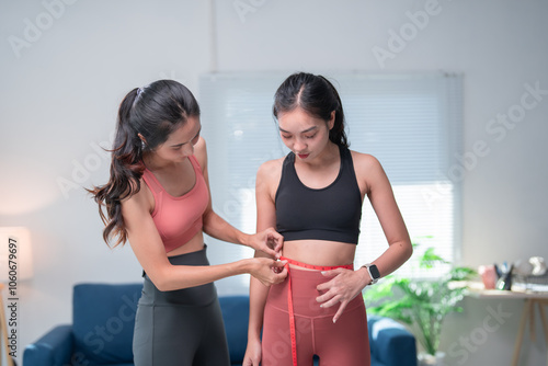 Εκτύπωση καμβά Young personal trainer measuring waist circumference of her client after success