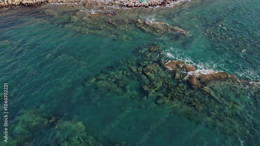 Clear blue water revealing rocky seabed near a coastal shoreline Clear blue water revealing rocky seabed near a coastal shoreline
