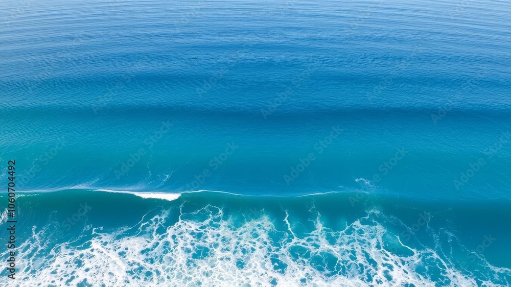 Beautiful aerial view of a vast ocean with waves crashing against the shore, showcasing the stunning blue hues of the water and white foam, serene, nature Beautiful aerial view of a vast ocean with waves crashing against the shore, showcasing the stunning blue hues of the water and white foam, serene, nature