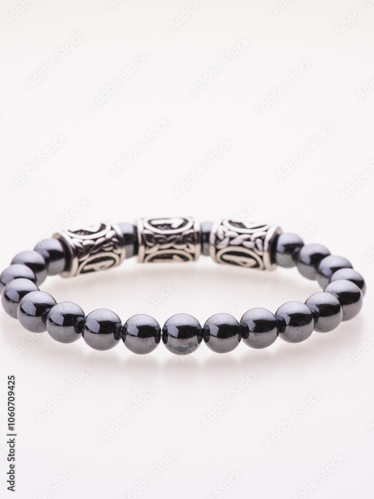 Obraz premium A charming double bracelet in shades of pink, made from natural stone and set against a gray background. The heart charm with cubic zirconia stands out in this close-up top view