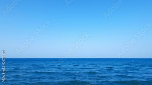 A serene ocean background with crystal clear blue water, gentle waves, and a cloudless sky, landscape, ocean