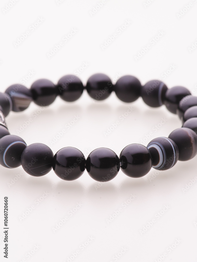 Obraz premium A charming double bracelet in shades of pink, made from natural stone and set against a gray background. The heart charm with cubic zirconia stands out in this close-up top view