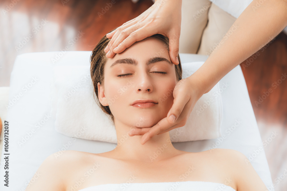 Naklejka premium Caucasian woman enjoying relaxing anti-stress head massage and pampering facial beauty skin recreation leisure in dayspa modern light ambient at luxury resort or hotel spa salon. Quiescent