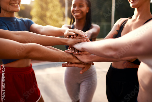 Team, fitness and women with hands together for basketball, exercise and game motivation with solidarity. Smile, workout and sport court outdoor with teamwork, athlete and group with support at match