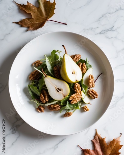fresh pear and walnut salad with autumn leaves on white marble background.