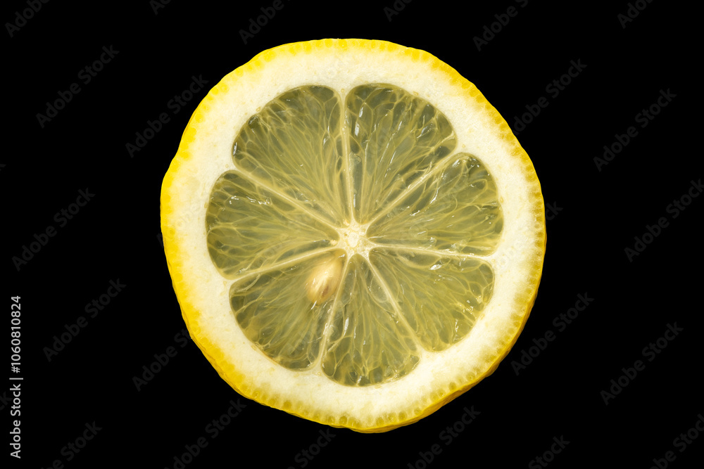 Cut lemon slice on black background. One pit visible. Cut lemon slice on black background. One pit visible.