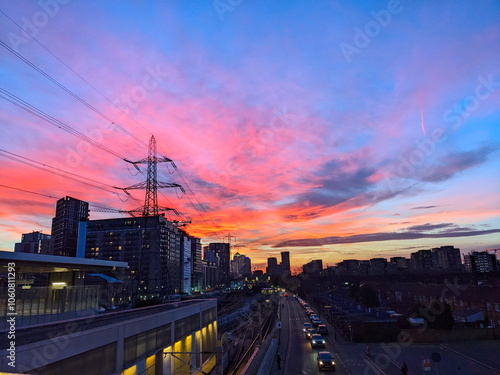 London, UK - 02.01.2024: Evening glow over Custom House Elizabeth Line and Docklands Light Railway station alongside cars queuing before a red light 