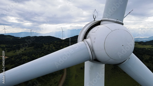 Serene Mountain Meadow with Distant Wind Turbines under Blue Sky 