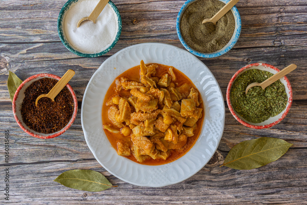 A dish from Turkish cuisine. Lamb tripe with chickpeas served on a white plate.