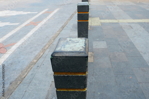 Bollards with yellow top paint on sidewalks, crossing in the city