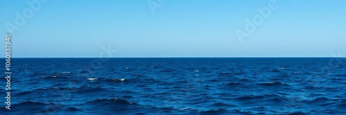 Vast expanse of deep blue ocean under a clear sky, with gentle waves and distant horizon, waves, scenic