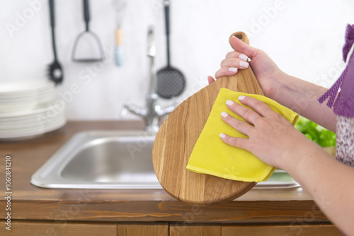 Bild auf Leinwand housewife wipes cutting board after washing